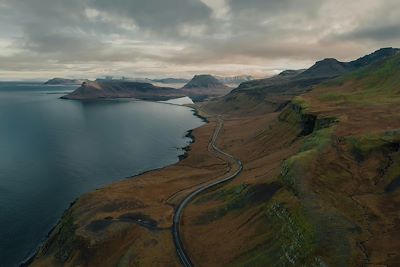 Une vue aérienne d'une route sinueuse longeant un fjord- Islande